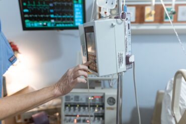 clinical photograph of a clinician operating an infusion pump